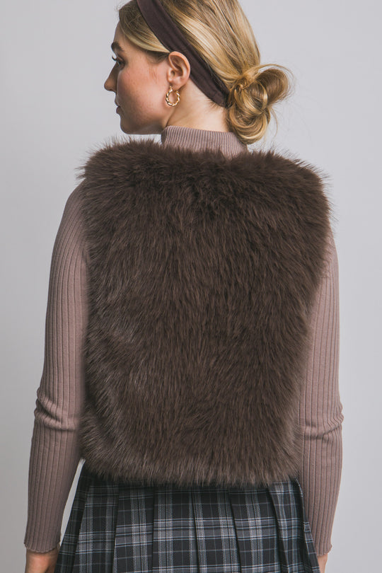 Chaleco corto de pelo sintético (faux fur) de textura ultra suave, peluda y de tacto acogedor.