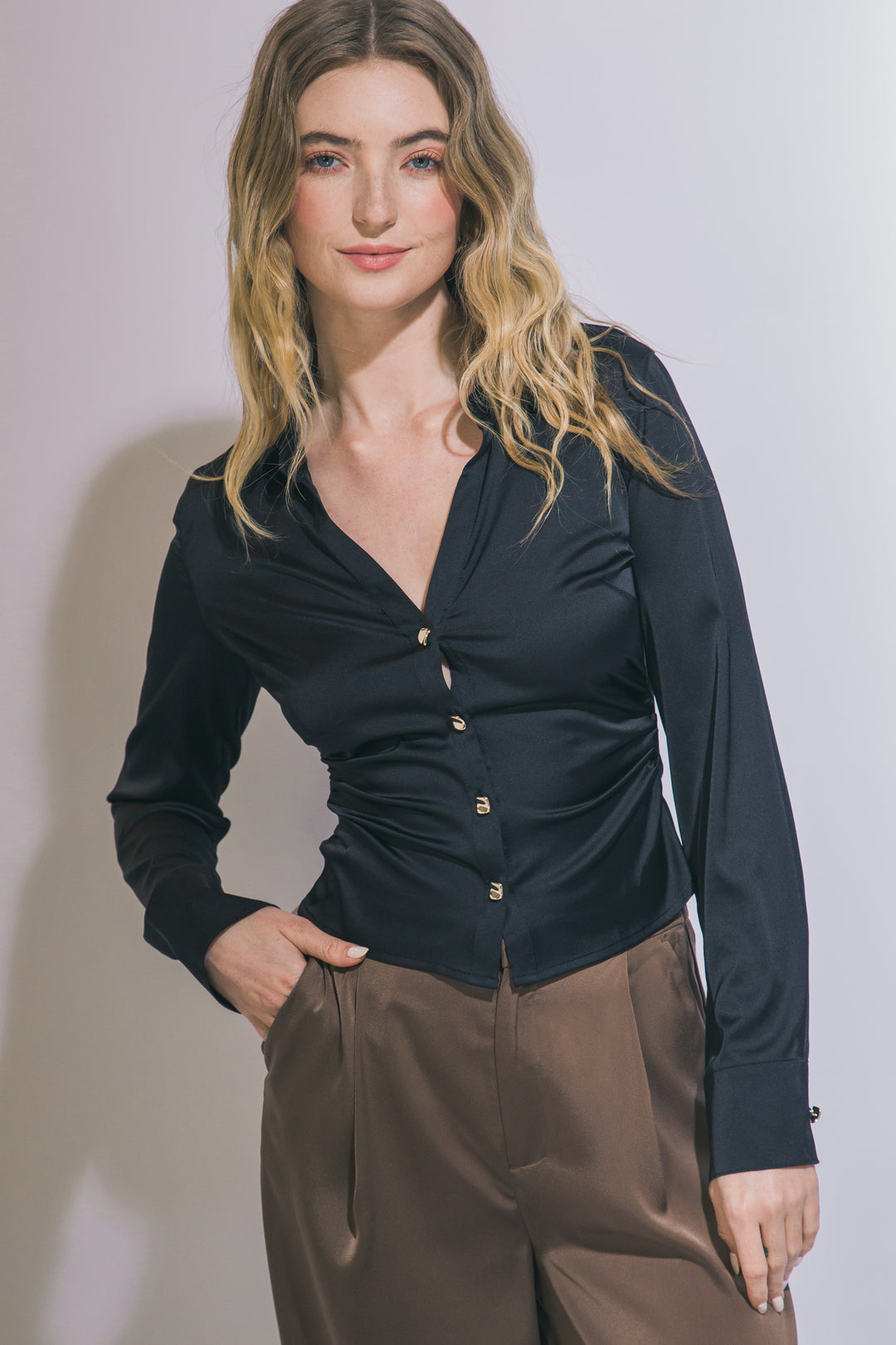 Elegante blusa de manga larga confeccionada en tejido satinado con un sutil acabado brillante
