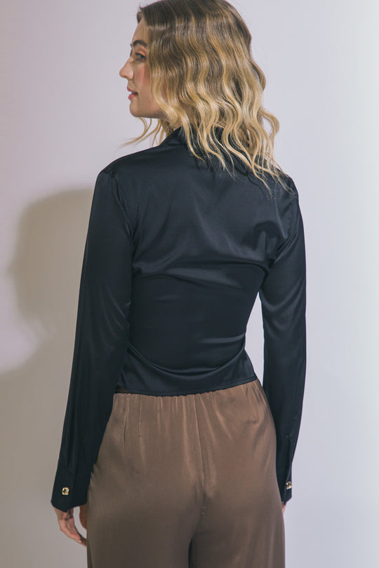 Elegante blusa de manga larga confeccionada en tejido satinado con un sutil acabado brillante