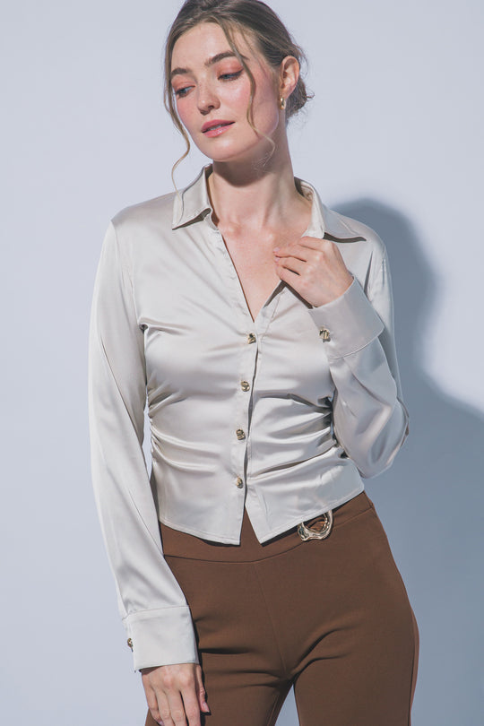 Elegante blusa de manga larga confeccionada en tejido satinado con un sutil acabado brillante