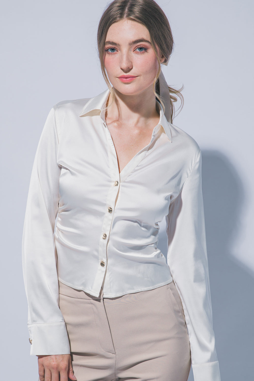 Elegante blusa de manga larga confeccionada en tejido satinado con un sutil acabado brillante