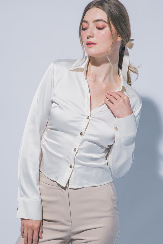 Elegante blusa de manga larga confeccionada en tejido satinado con un sutil acabado brillante