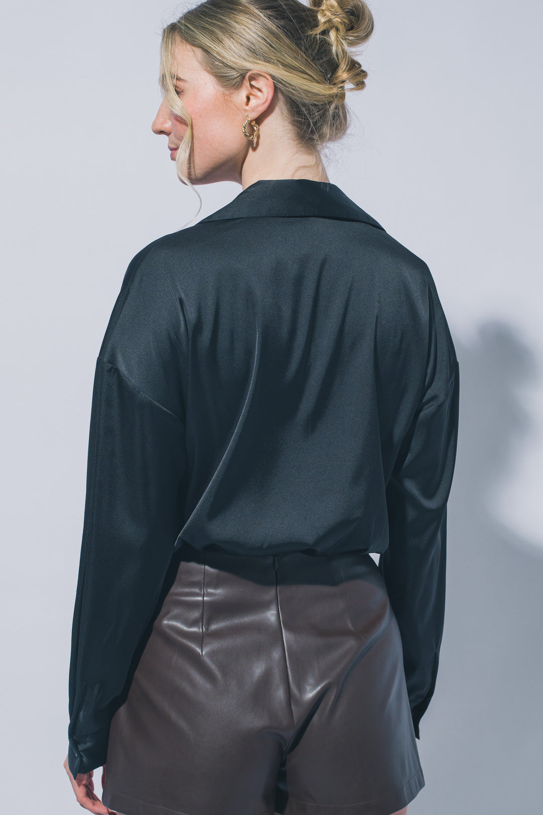 Pantiblusa estilo camisa satinada en tono perla/champán, diseñada para brindar un ajuste elegante y estilizado.