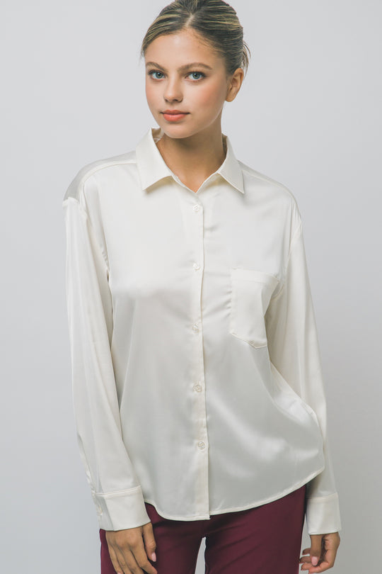 Elegante blusa de manga larga confeccionada en tejido satinado con un sutil acabado brillante en tono arena/champán