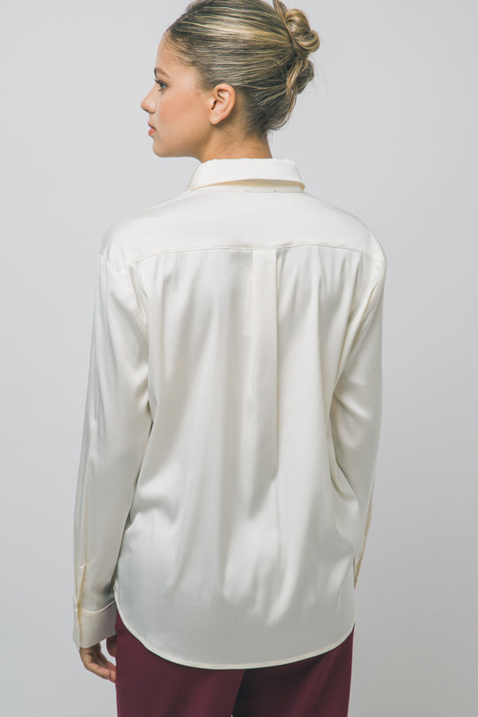 Elegante blusa de manga larga confeccionada en tejido satinado con un sutil acabado brillante en tono arena/champán