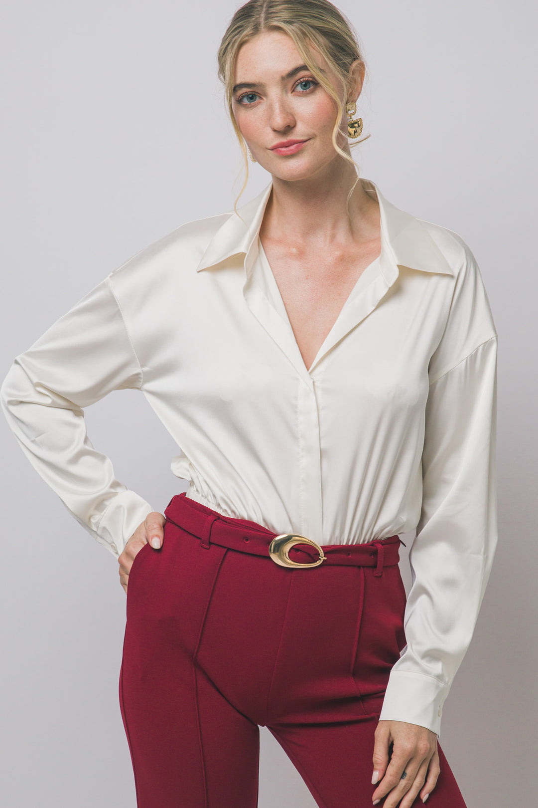 Pantiblusa estilo camisa satinada en tono perla/champán, diseñada para brindar un ajuste elegante y estilizado.