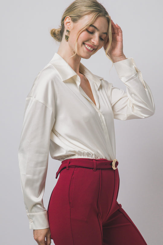 Pantiblusa estilo camisa satinada en tono perla/champán, diseñada para brindar un ajuste elegante y estilizado.