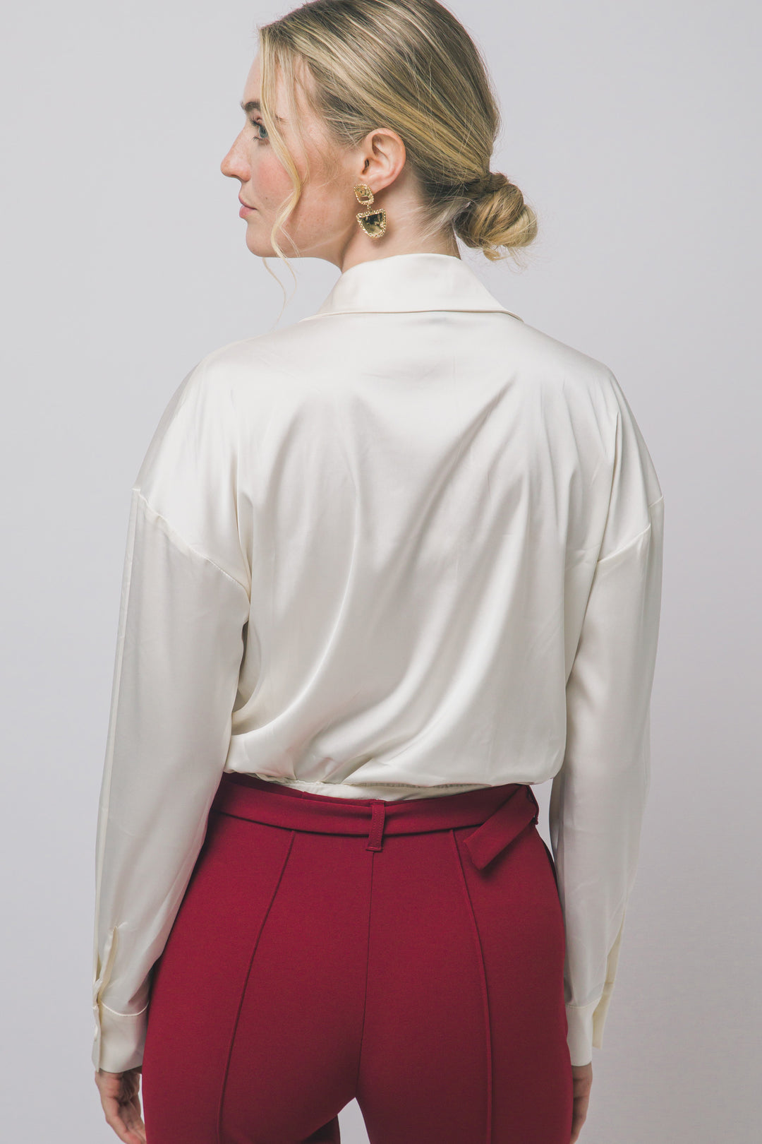 Pantiblusa estilo camisa satinada en tono perla/champán, diseñada para brindar un ajuste elegante y estilizado.