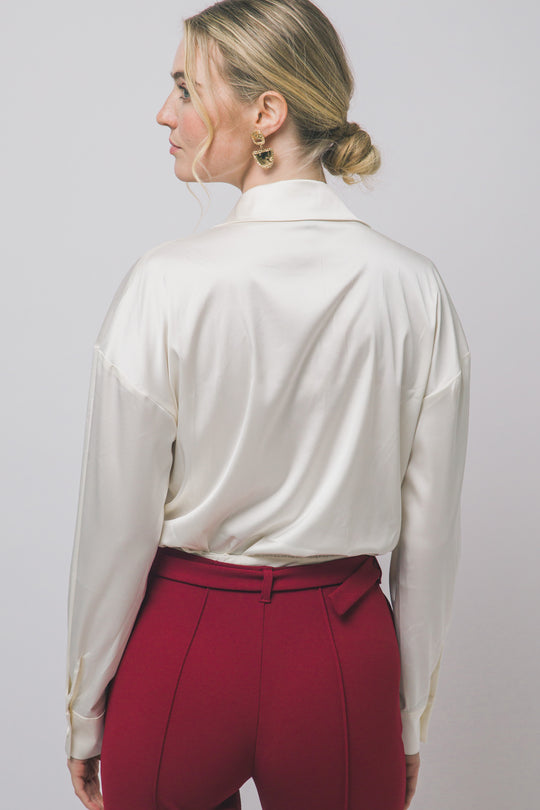 Pantiblusa estilo camisa satinada en tono perla/champán, diseñada para brindar un ajuste elegante y estilizado.