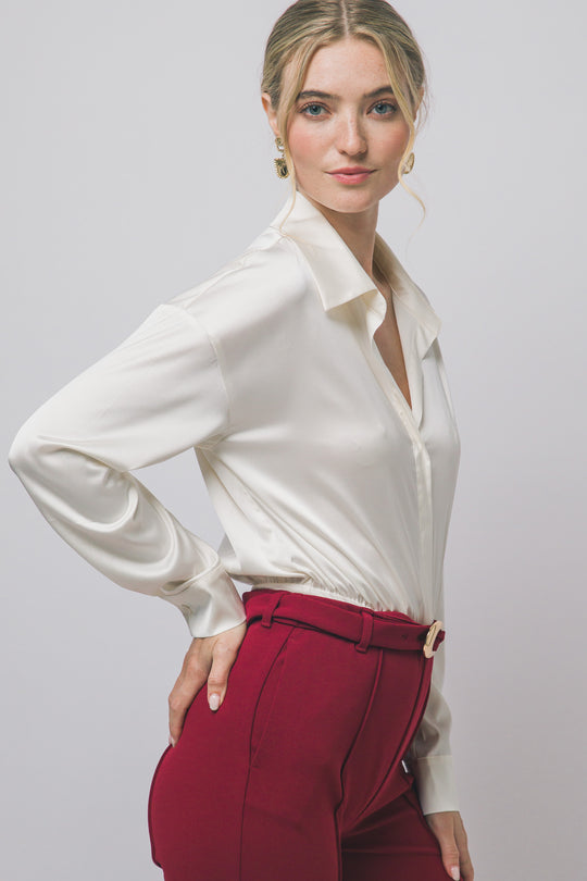 Pantiblusa estilo camisa satinada en tono perla/champán, diseñada para brindar un ajuste elegante y estilizado.