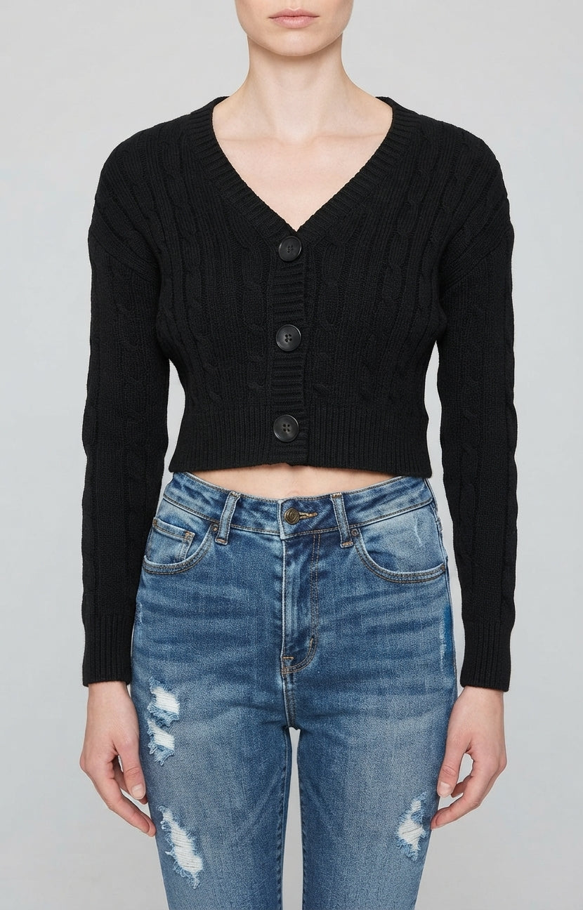 Un suéter de punto trenzado en color crema, con cuello en V y cierre frontal de tres botones